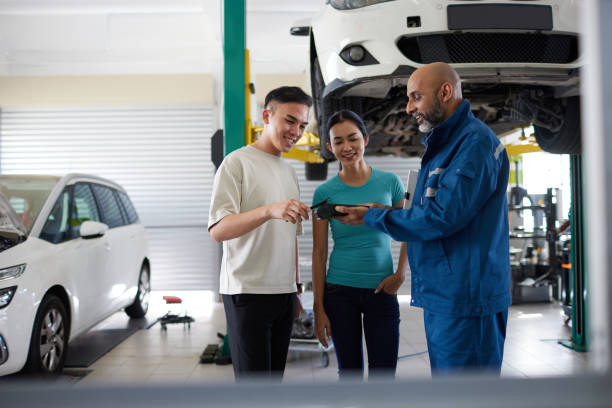 Service advisor showing a digital job card to customers in an automobile workshop